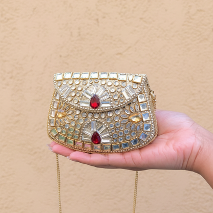 Ishika Mini Kundan Clutch held in hand with painted nails against limewash textured background