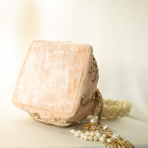 Soft Nude Peach Velvet potli bag with gold Zardozi hand embroidery, and pearl handle