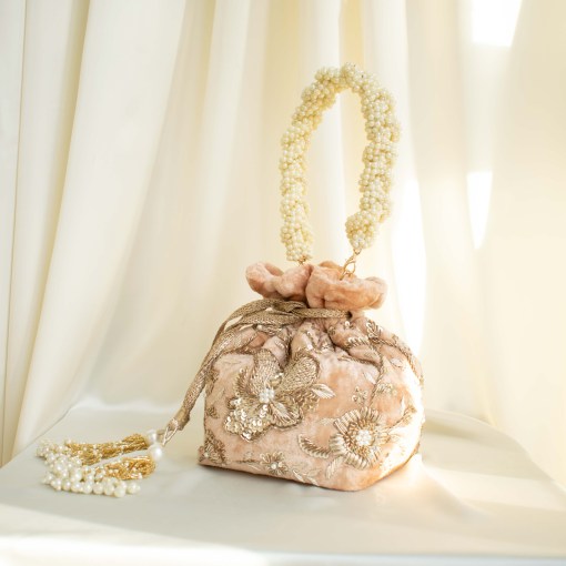 Soft Nude Peach Velvet potli bag with gold Zardozi hand embroidery, and pearl handle